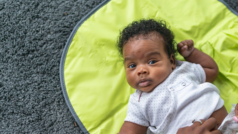 Cute baby laying on may waiting for diaper change